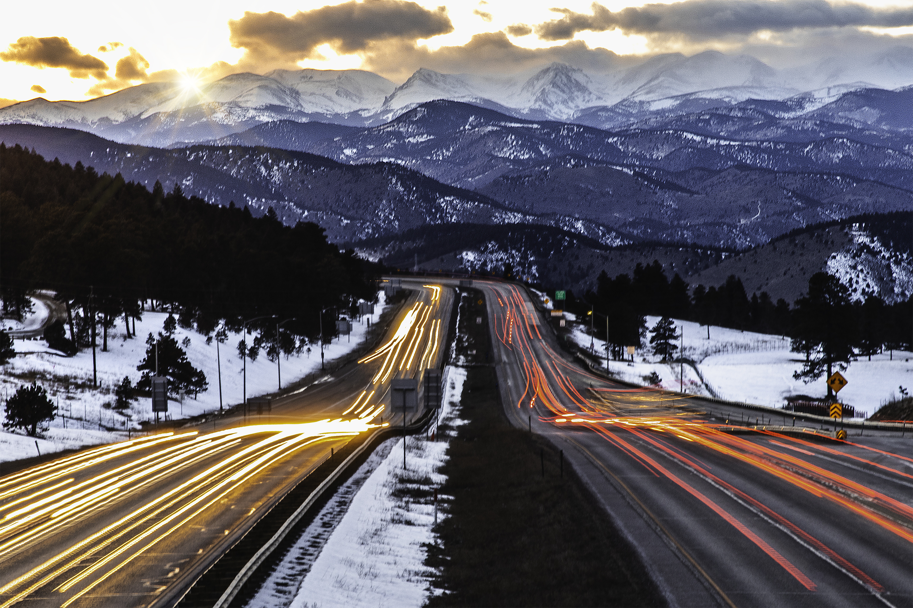 Car trail in mountains at sunset