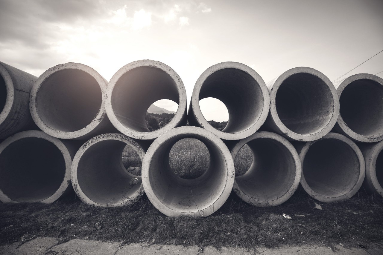 Concrete Pipes Stacked with Sun in Background